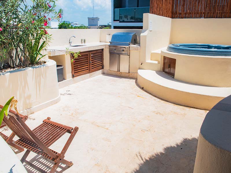 Entrada al Condo 207 desde sendero rodeado de palmeras y plantas tropicales