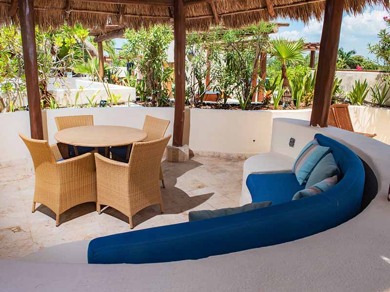 Fachada del Condo 207 con acceso desde jardín tropical y senderos iluminados